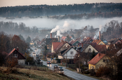 vesnice v údolí, kde kouří hodně komínů a je tu smog, v okolí na kopcích je les, kopce jsou nízké, v údolí také jede několik aut po silnici